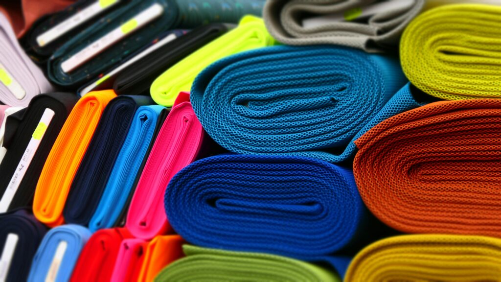 Colorful fabrics neatly rolled and displayed in a textile store.